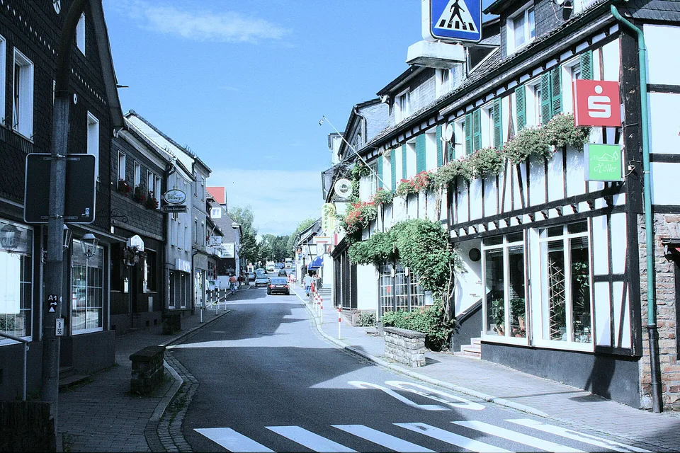Hauptstraße in Much mit Fachwerkfassaden und Geschäften