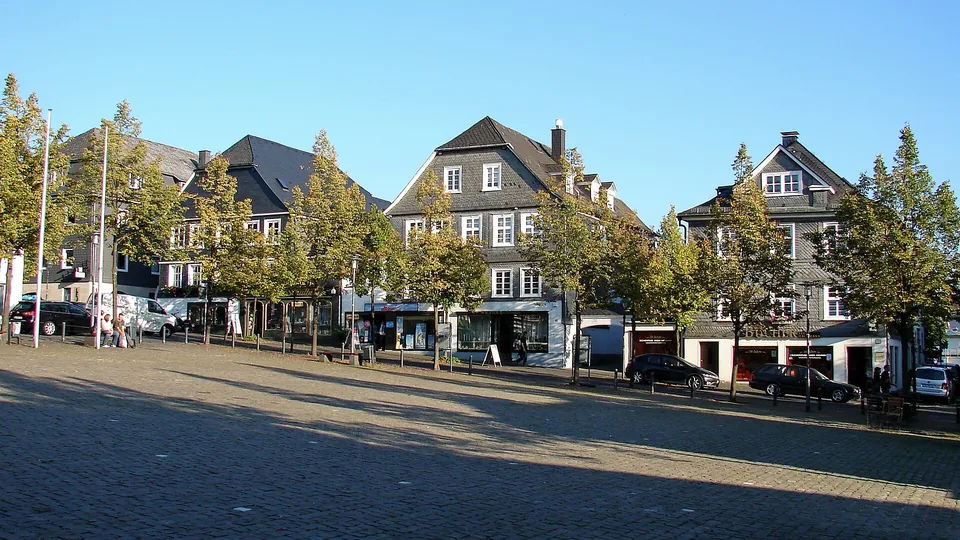 Marktplatz in Olpe mit Häuserfassaden und Baumreihe