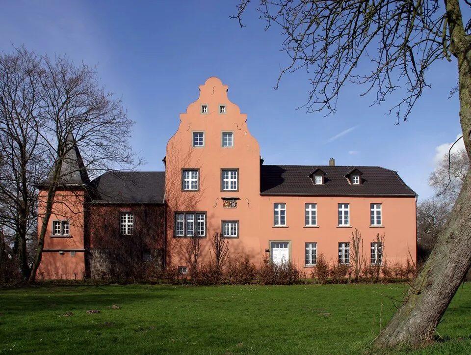 Haus Broich in Troisdorf-Spich mit rosafarbener Fassade und Parkwiese